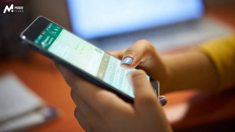 Empreendedor segurando o celular com o whatsapp business